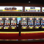 O scene with a gambler in a tuxedo playing a slot machine that is made up of various cryptocurrency coins