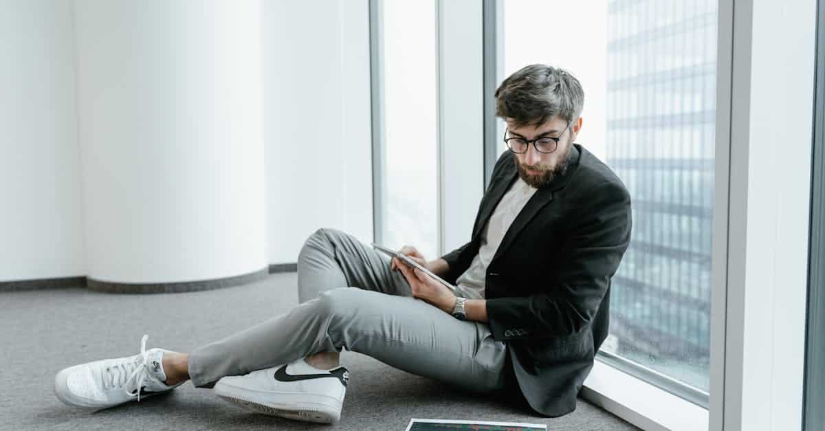 a man wearing black jacket looking at graphs on the floor