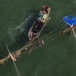 an aerial view of a fishing boat in the water